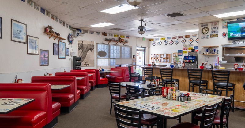 Cozy diner with vintage charm featuring red booths, a counter with bar stools