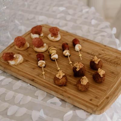Assorted appetizer bites on a wooden board.