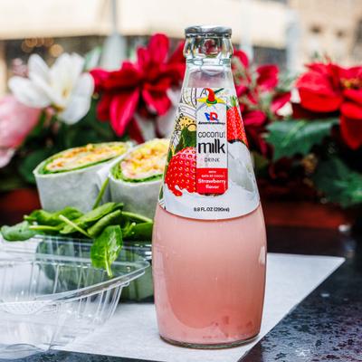 Strawberry Coconut Milk drink served alongside a wrap in plastic container.