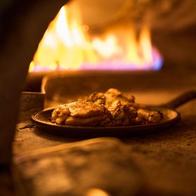 Food being cooked in a wood-fired oven.