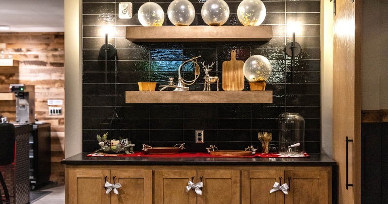 Decorated serving area with globe lights, deer figurines and a red table runner