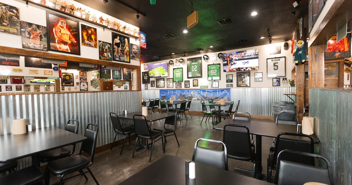 Interior, dining area, tables and chairs ready for guests, framed and signed WWE posters