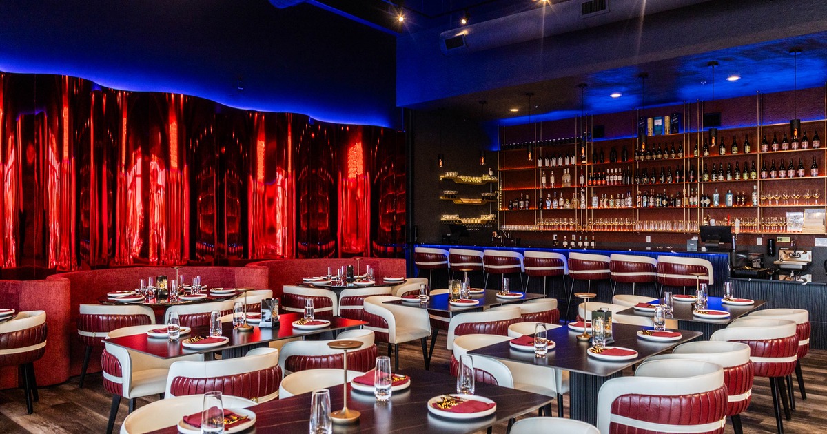 Interior - red and blue accents, plush seating, tables, red and white settings; a well-stocked bar