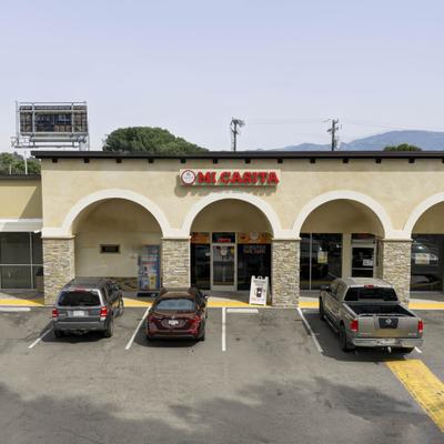 Restaurant exterior with arches and parked cars.