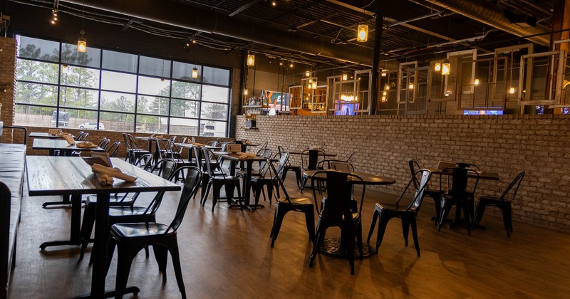 Interior, spacious seating area with large windows in the back