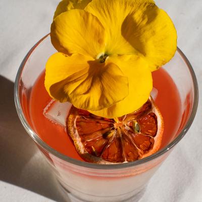 Orange cocktail with a flower.