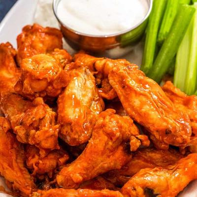 Buffalo wings served with celery sticks and a dipping sauce.