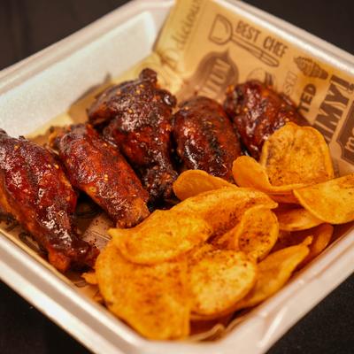 Chicken wings served with seasoned chips.