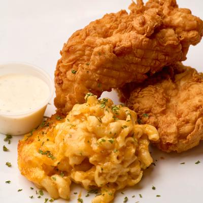 Fried chicken tender with mac and cheese and a dip.
