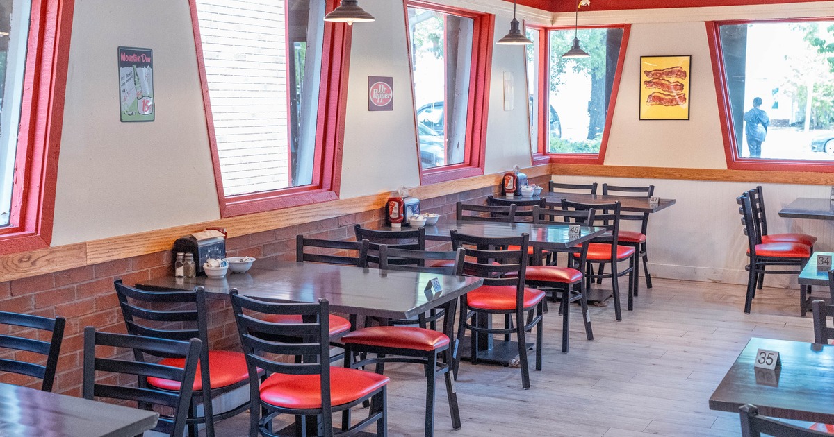 Interior -  black and red chairs, slanted windows with red frames, hanging lights.