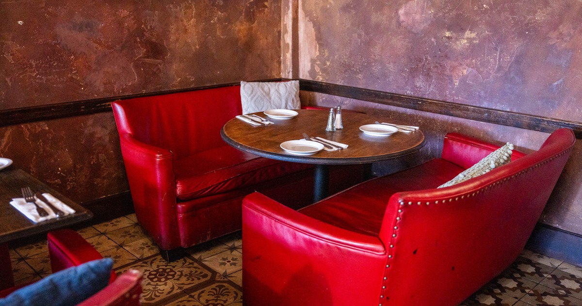 Interior, dining area, vintage two seater sofas with round wooden table, ready for guests
