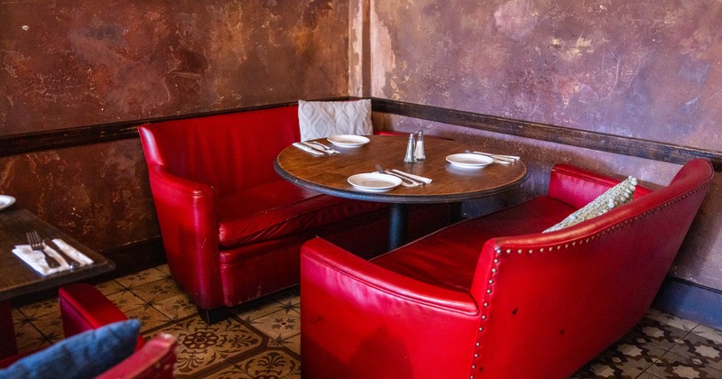 Interior, dining area, vintage two seater sofas with round wooden table, ready for guests