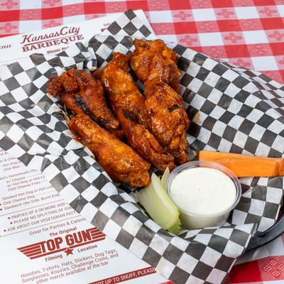 Chicken wings, celery and carrots with a sauce.