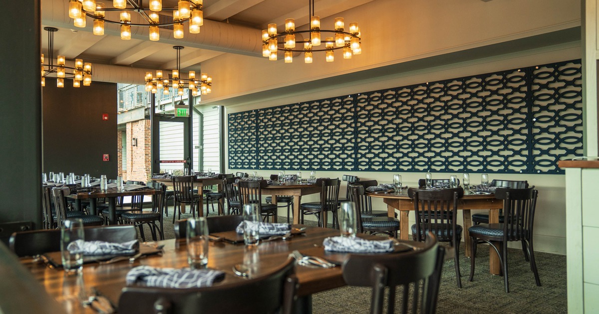 Interior, wooden tables, black chairs, decorative light fixtures, and a patterned wall