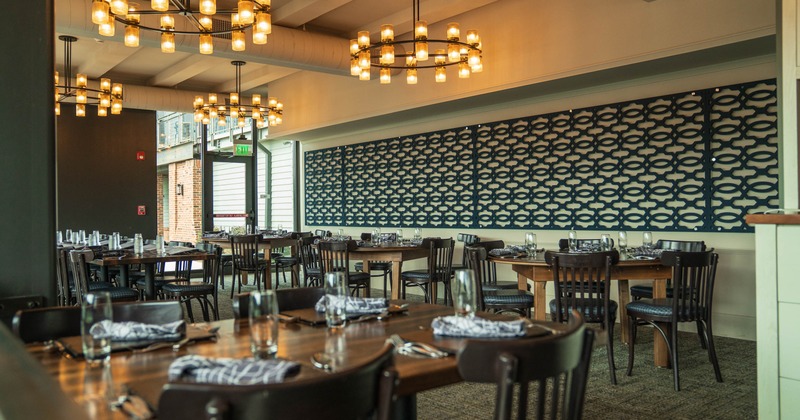 Interior, wooden tables, black chairs, decorative light fixtures, and a patterned wall