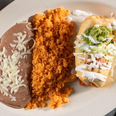 Chimichanga with refried beans and rice on a plate.