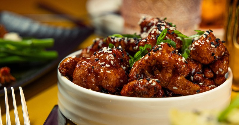 Sambal Cauliflower topped with sesame seeds and scallions, close-up
