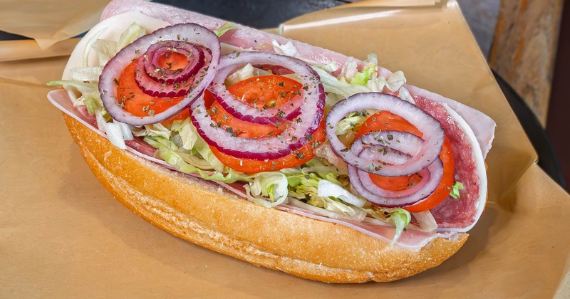 Italian hoagie filled with lettuce, tomatoes and onions