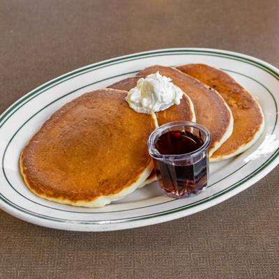 4 stack of pancakes with butter and syrup.