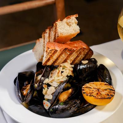 Steamed mussels with garlic, grilled bread, and charred lemon.