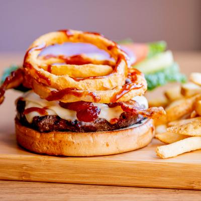 Brothers Burger served on a wooden board with fries.