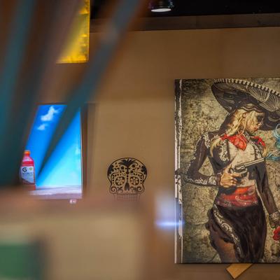 Day-of-the-dead-themed artwork on a wall.