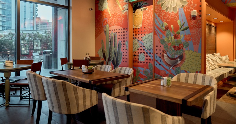 Tables and armchairs, angle by window