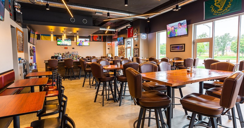 Dining tables and seats, and a bar in the back