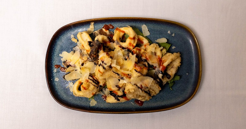 Top-down view of fried calamari with balsamic and Parmesan