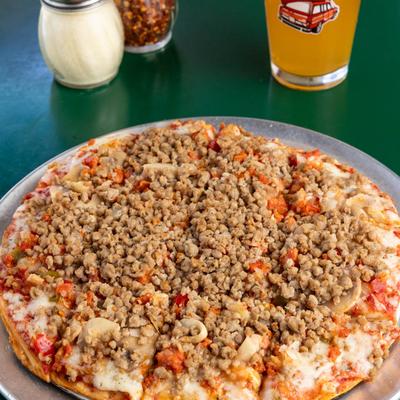 Royal Feast pizza on a table, a glass of beer is nearby.