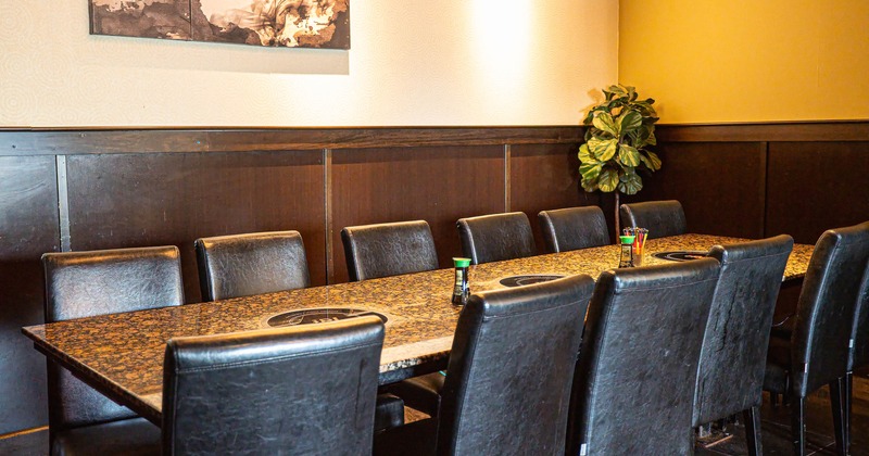 Dining room with a long granite table and ten black chairs