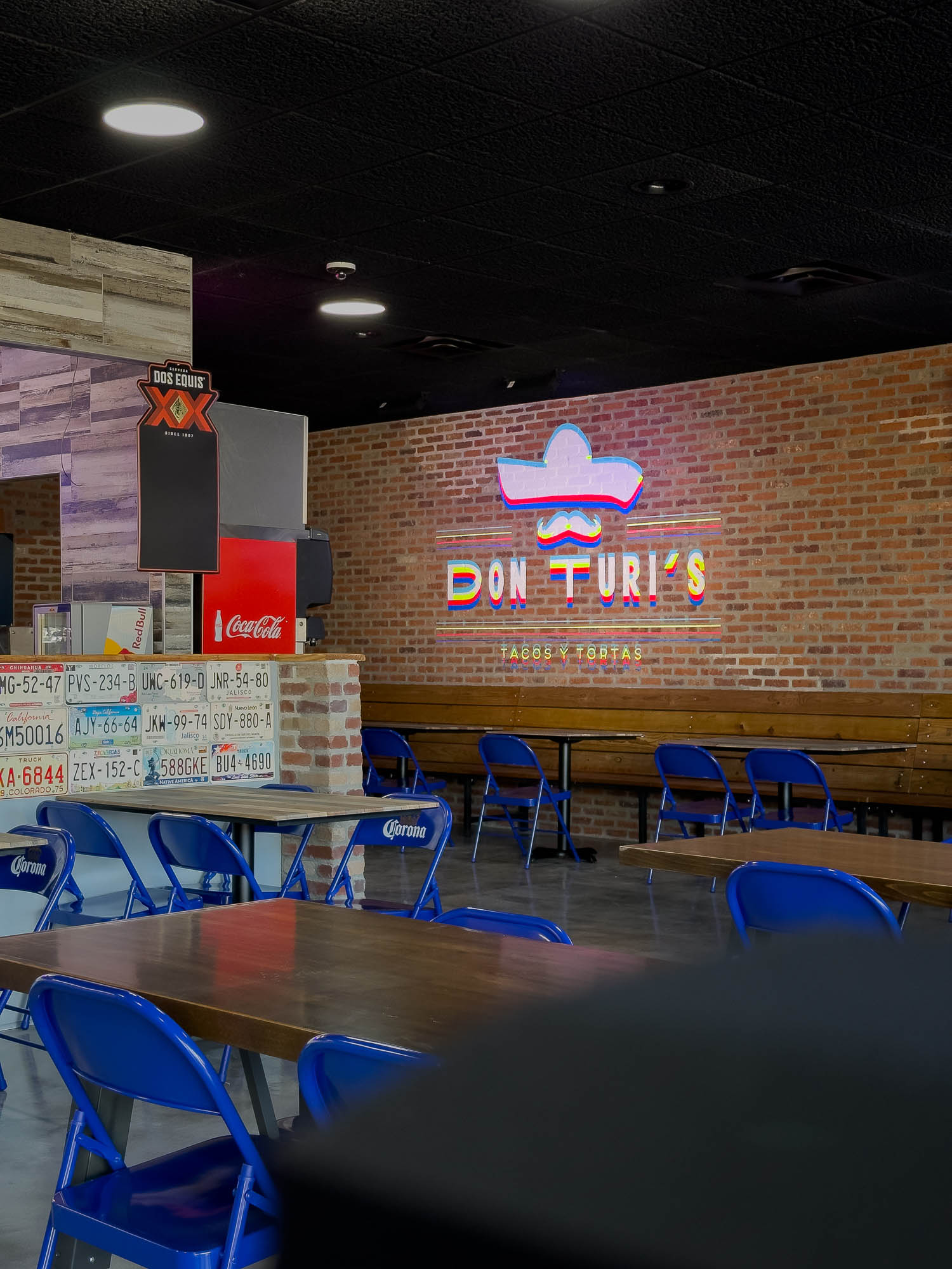 Don Turi’s dining room with a brick wall logo and blue chairs