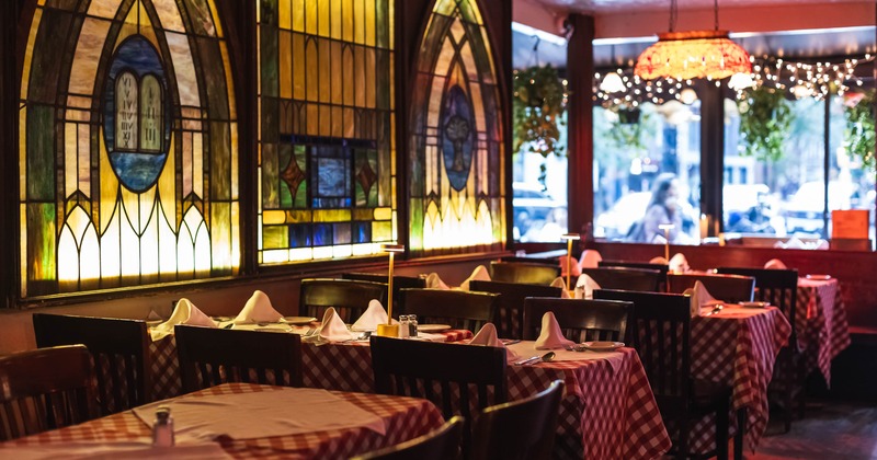 Interior, dining area, tables with classic checkered red and white cloths for six, wooden chairs