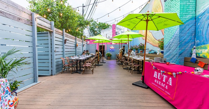 Outdoor dining area with set tables, chairs, and parasols