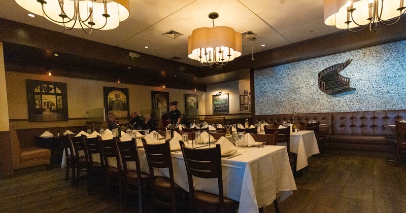 Warmly lit restaurant interior with set dining tables and abstract wall art