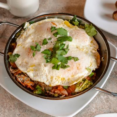 Veggie Skillet topped with fried eggs and fresh herbs.