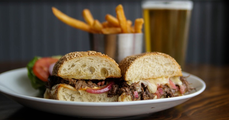 Cheese steak sandwich with fries and beer