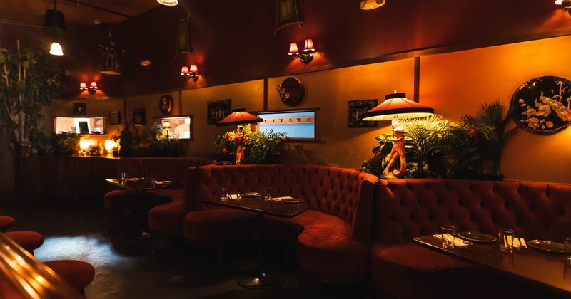 Dimly lit interior dining space with half booths, ambient lighting
