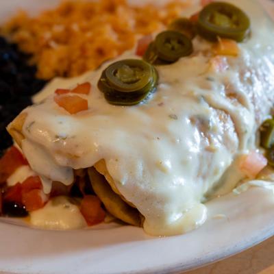 Chicken Chimichanga, smothered in cheese, served with rice and beans.