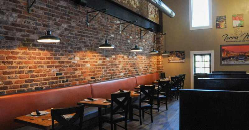 Tables neatly lined up along the brick wall, discreet lighting