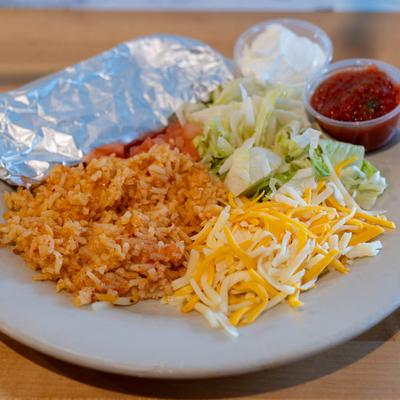 Fajitas, served with lettuce, tomato, cheese, rice, and salsa.