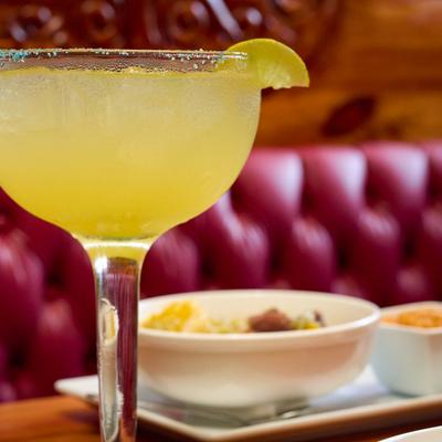 Yellow cocktail in a stemmed glass with lime.