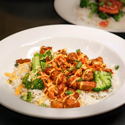 Teriyaki steak bites with broccoli on a bed of rice.