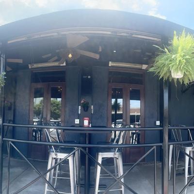 Covered outdoor patio area with dark-toned walls and elevated seating.