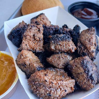 Burnt ends served with bread and dipping sauces.