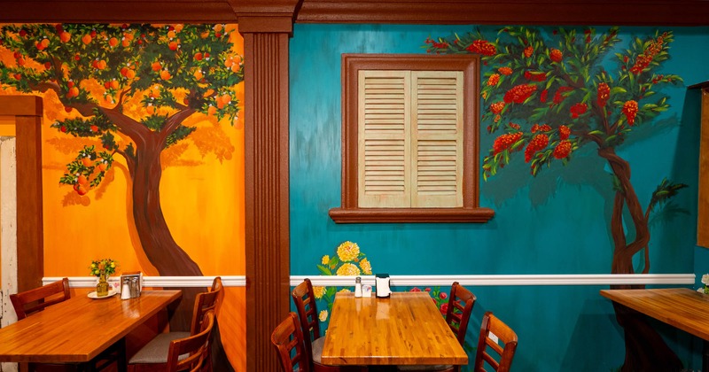 Tables along a colorful painted wall