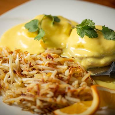 Eggs Benedict with hash browns, close up.