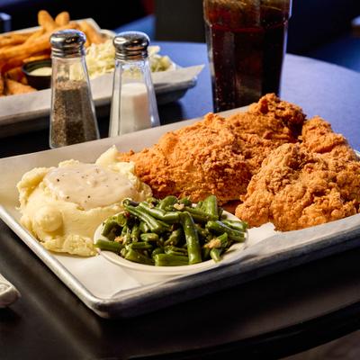 Fried chicken served with green beans and mashed potatoes.