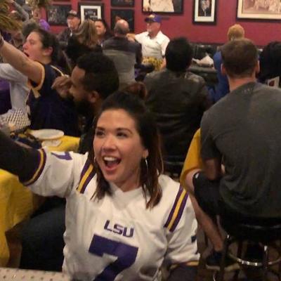 A girl in a white jersey in the crowd cheering