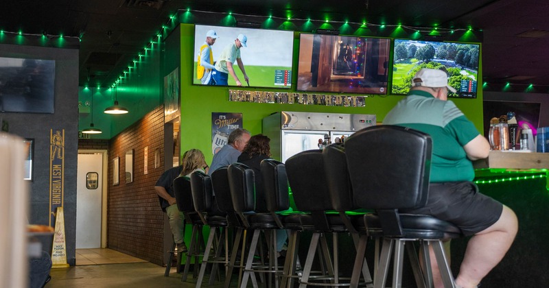 Interior, bar area, bar and bar stools, guests sitting at the bar